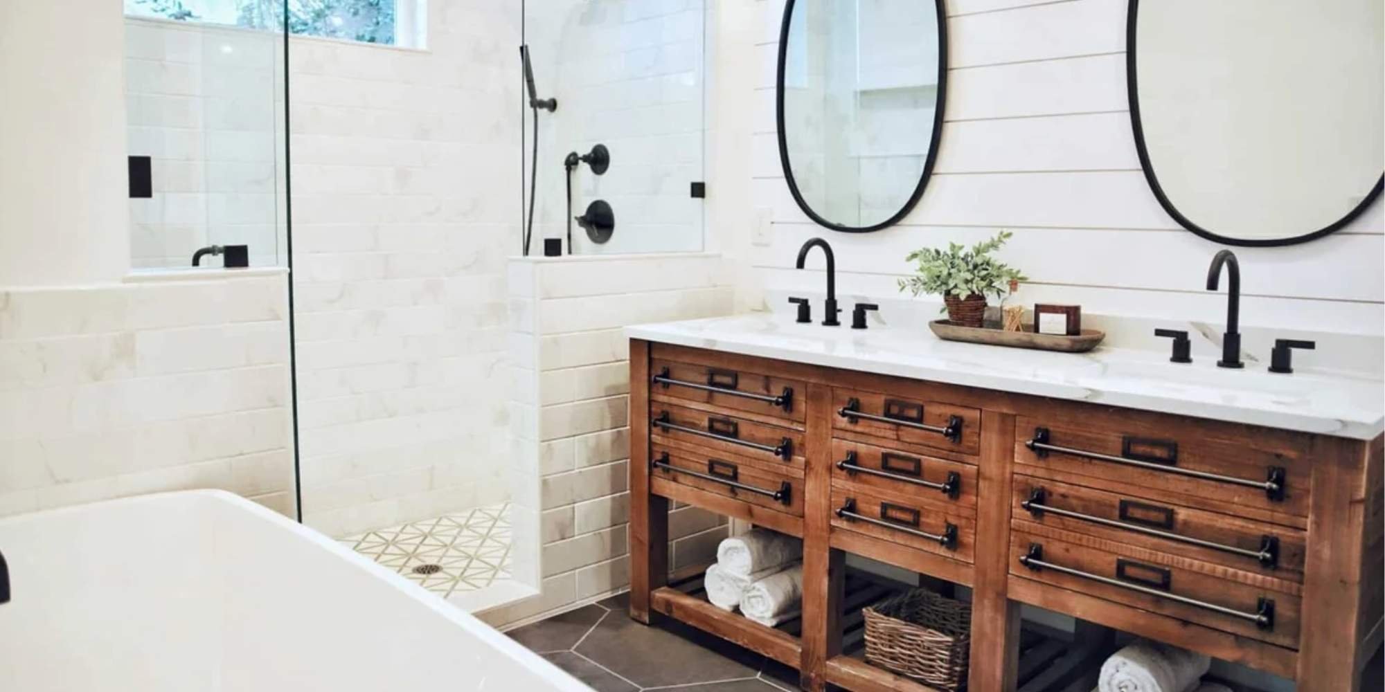 Updated bathroom featuring dual mirrors, soaking tub, and natural wood cabinetry by Doxa Custom Homes