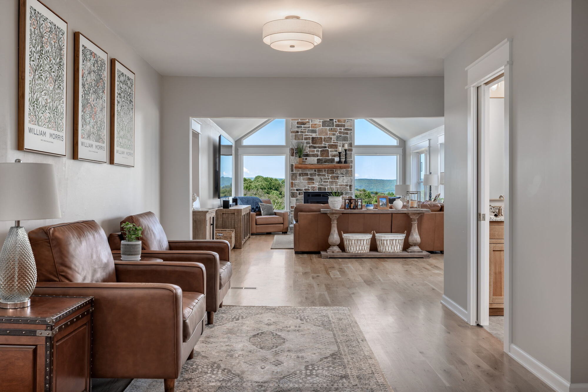 Hallway view leading to vaulted living room with fireplace in a custom home by Doxa Custom Homes in Murfreesboro, TN