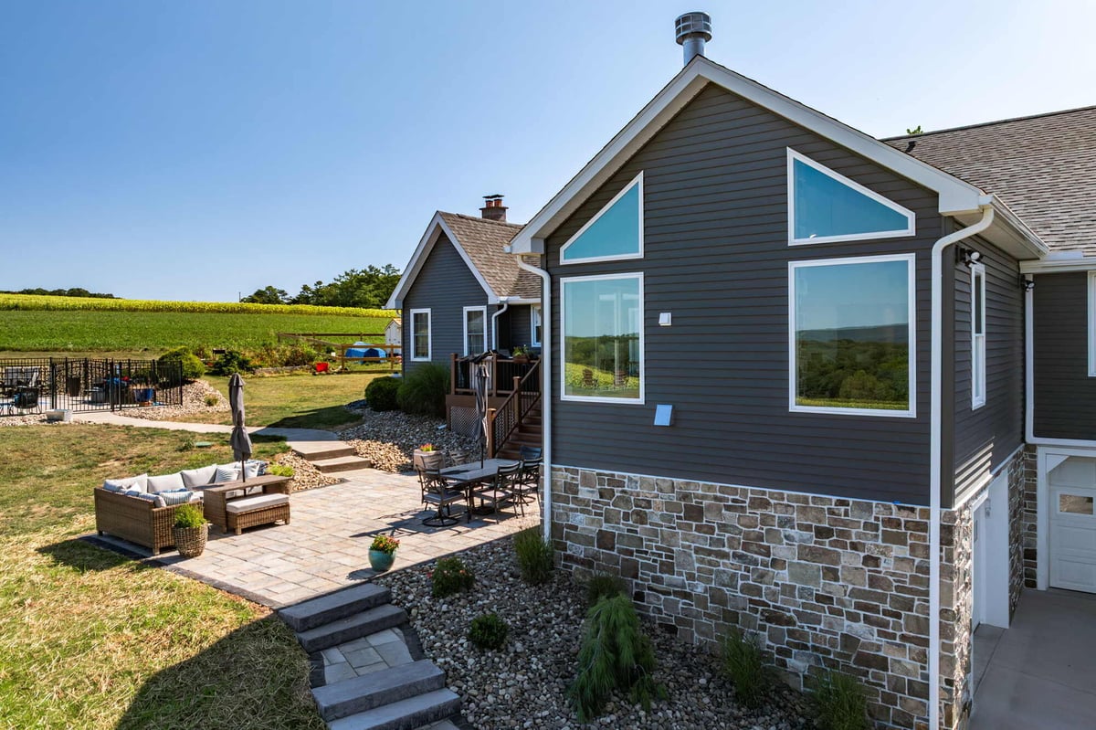 Outdoor seating area with pavers and stonework in Crossville custom home by Doxa Custom Homes