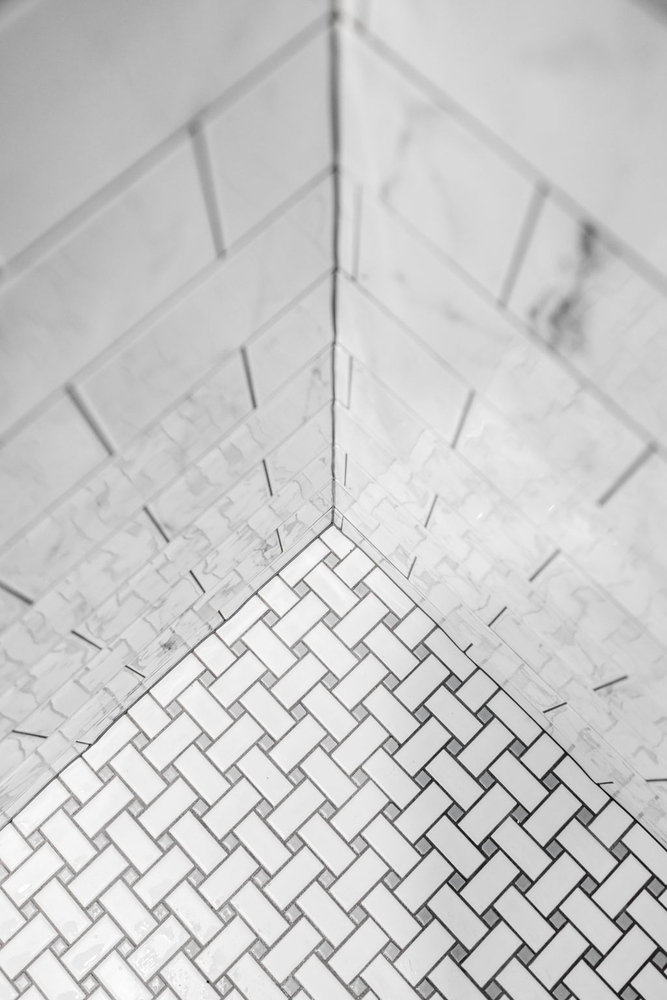 Built-in shower niche with marble tile in a custom bathroom by Doxa Custom Homes in Murfreesboro, TN