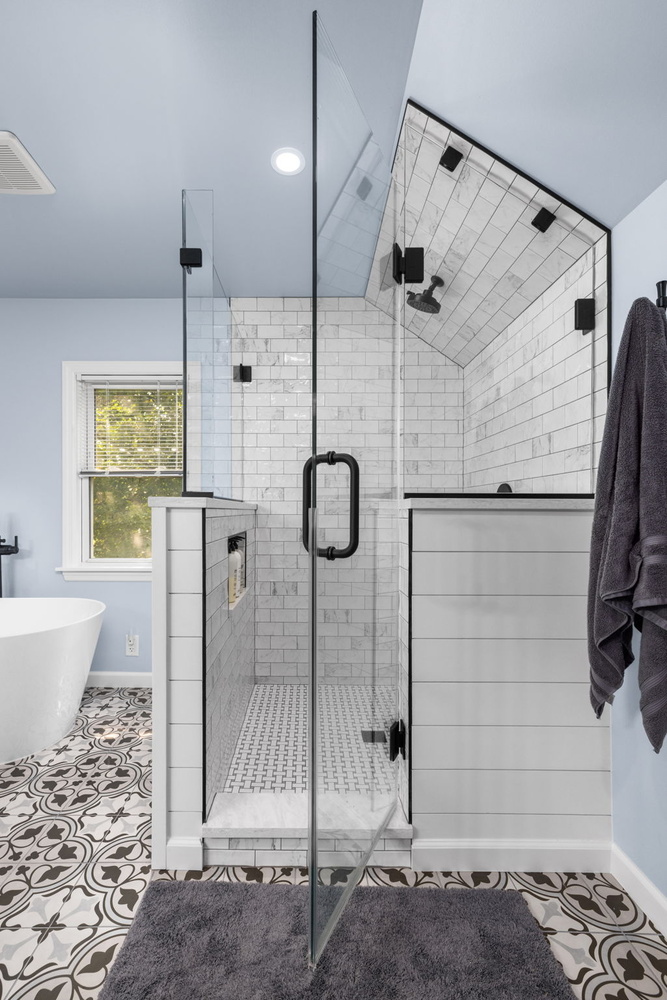 Elegant walk-in shower design with decorative flooring by Doxa Custom Homes in Murfreesboro, TN