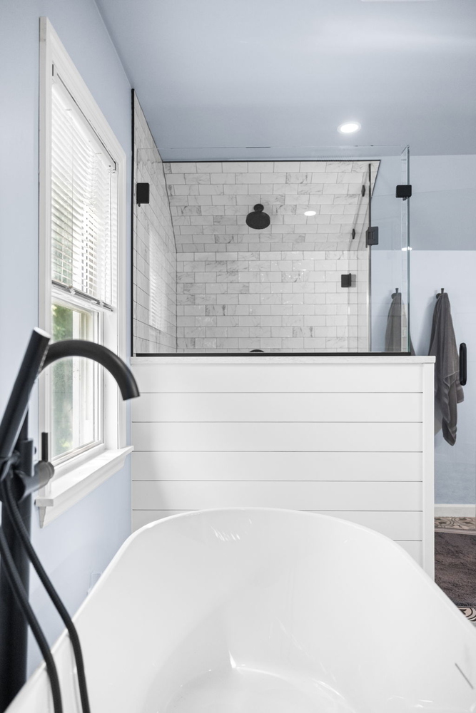 Matte black tub filler with freestanding white bathtub in custom bathroom by Doxa Custom Homes in Murfreesboro, TN