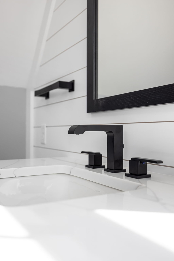 Close-up of black fixtures and white vanity countertop by Doxa Custom Homes in Cookeville, Tennessee
