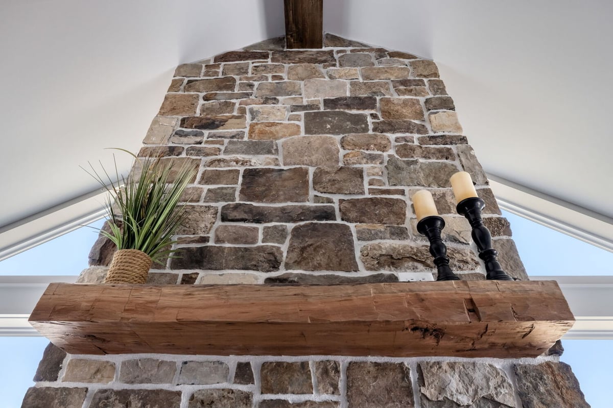 Close-up of rustic wood mantel on stone fireplace in custom home by Doxa Custom Homes in Tennessee