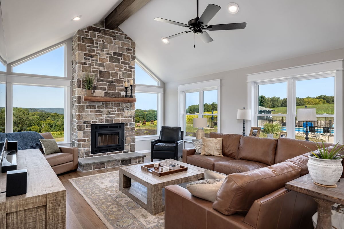 Open-concept living room with vaulted ceiling and stone fireplace by Doxa Custom Homes in Lebanon, TN