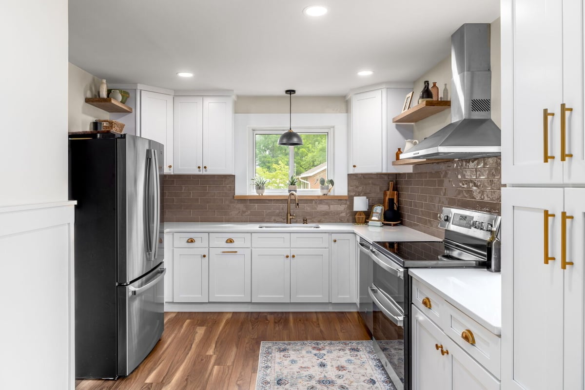 Full kitchen layout with white cabinetry, wood floors, and matte bronze finishes by Doxa Custom Homes in Tennessee