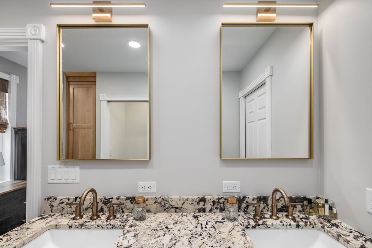 Double vanity with granite countertops and gold fixtures in custom home by Doxa Custom Homes in Lebanon, TN