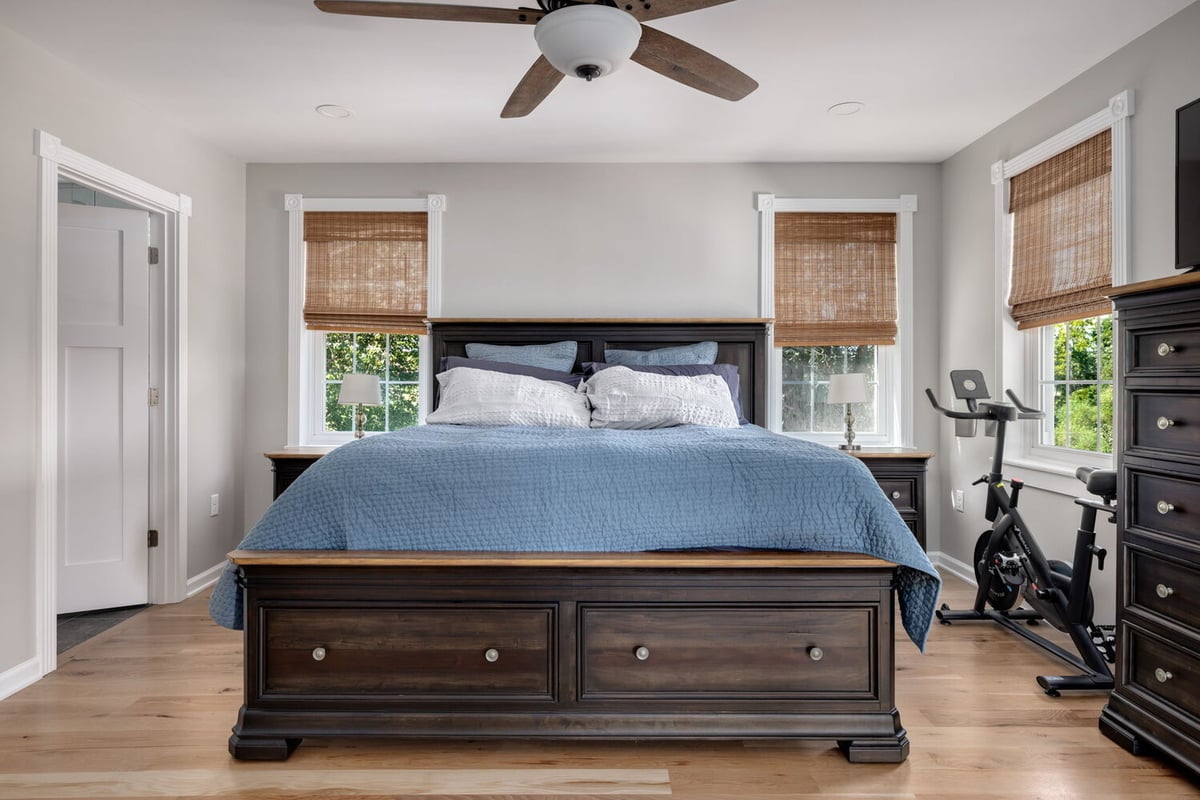 Master bedroom with large dark wood bed and blue bedding in custom home by Doxa Custom Homes in Cookeville, TN
