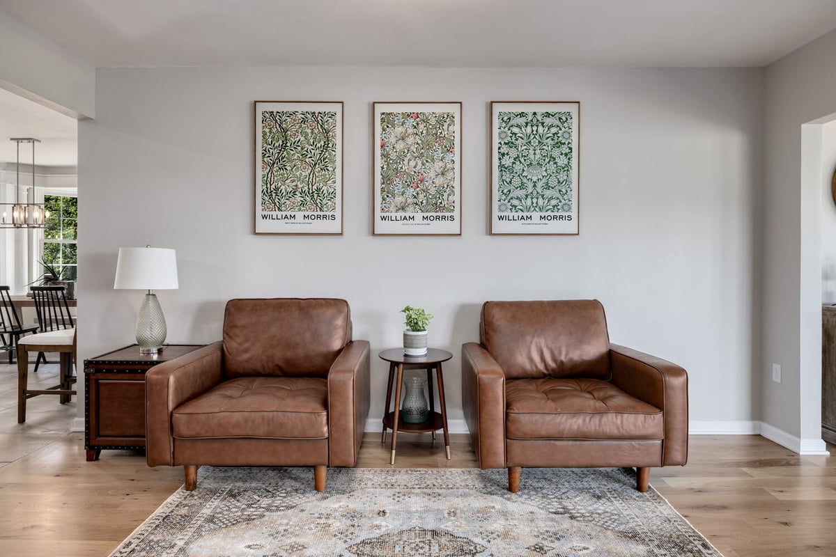Sitting area with leather armchairs and William Morris artwork in custom home by Doxa Custom Homes in Crossville, TN